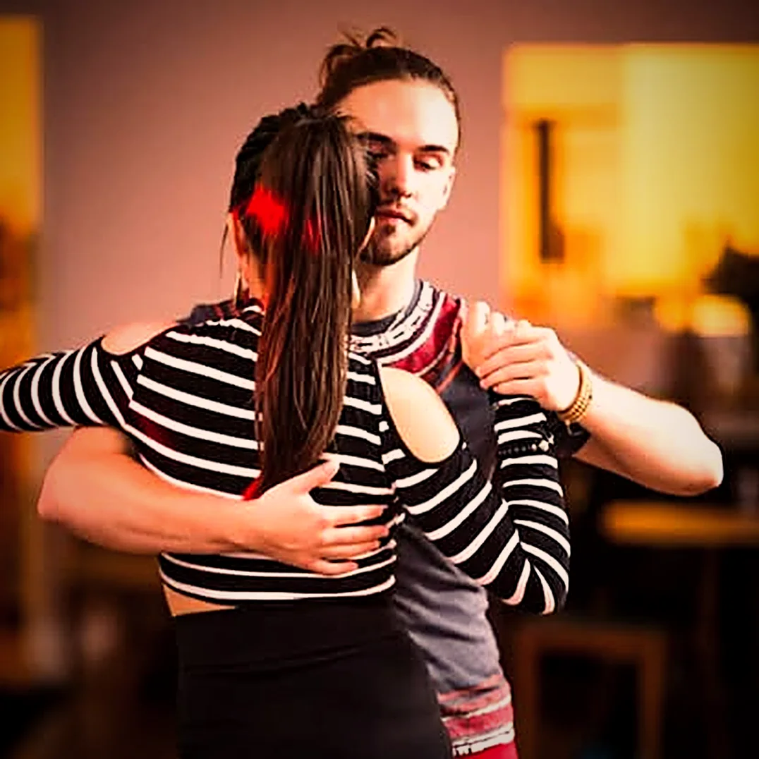 James guiding a partner through a close dance hold